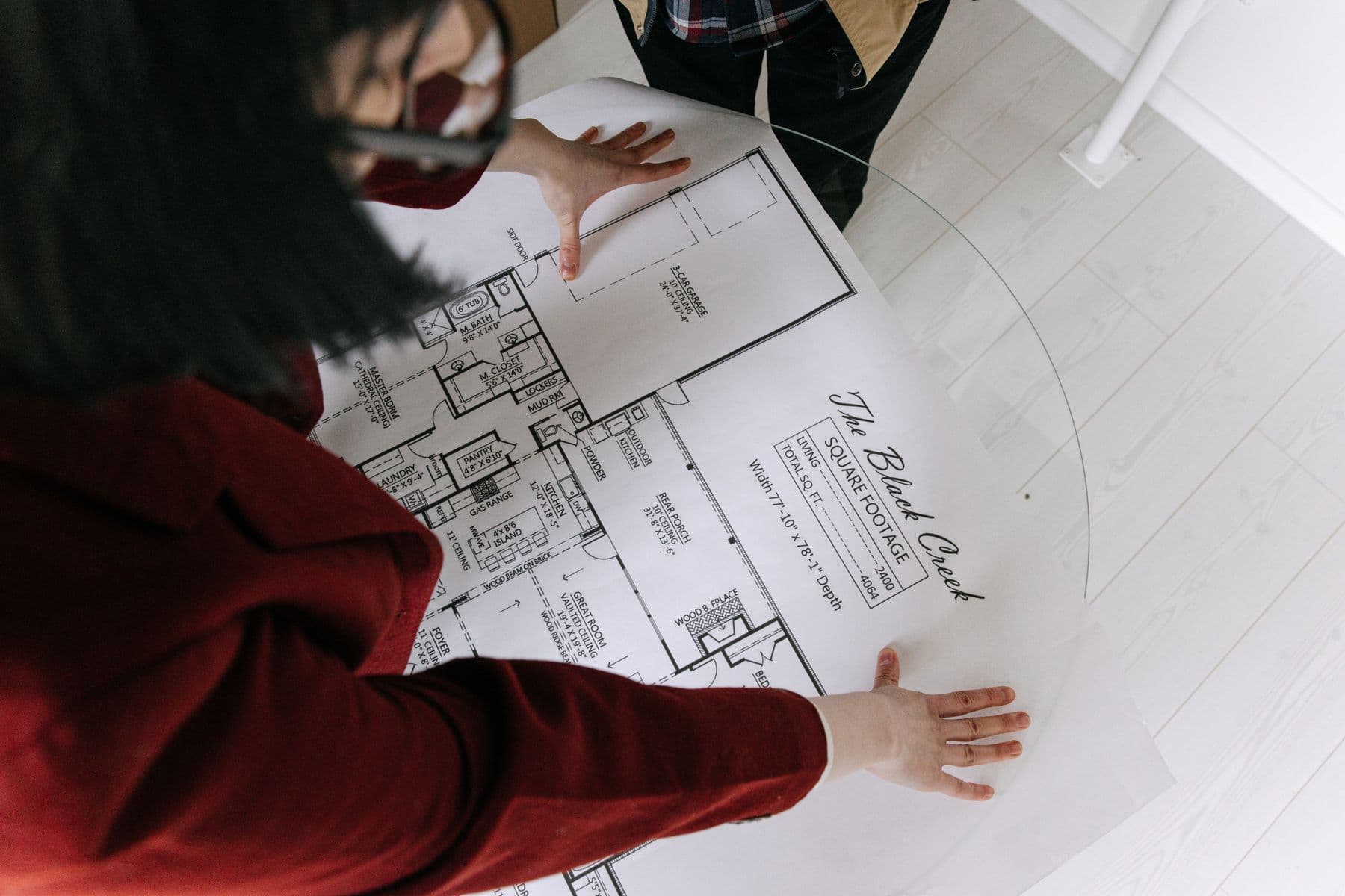 Real-estate professionals reviewing a residential floor plan together.